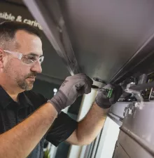 A person performing maintenance on a door.